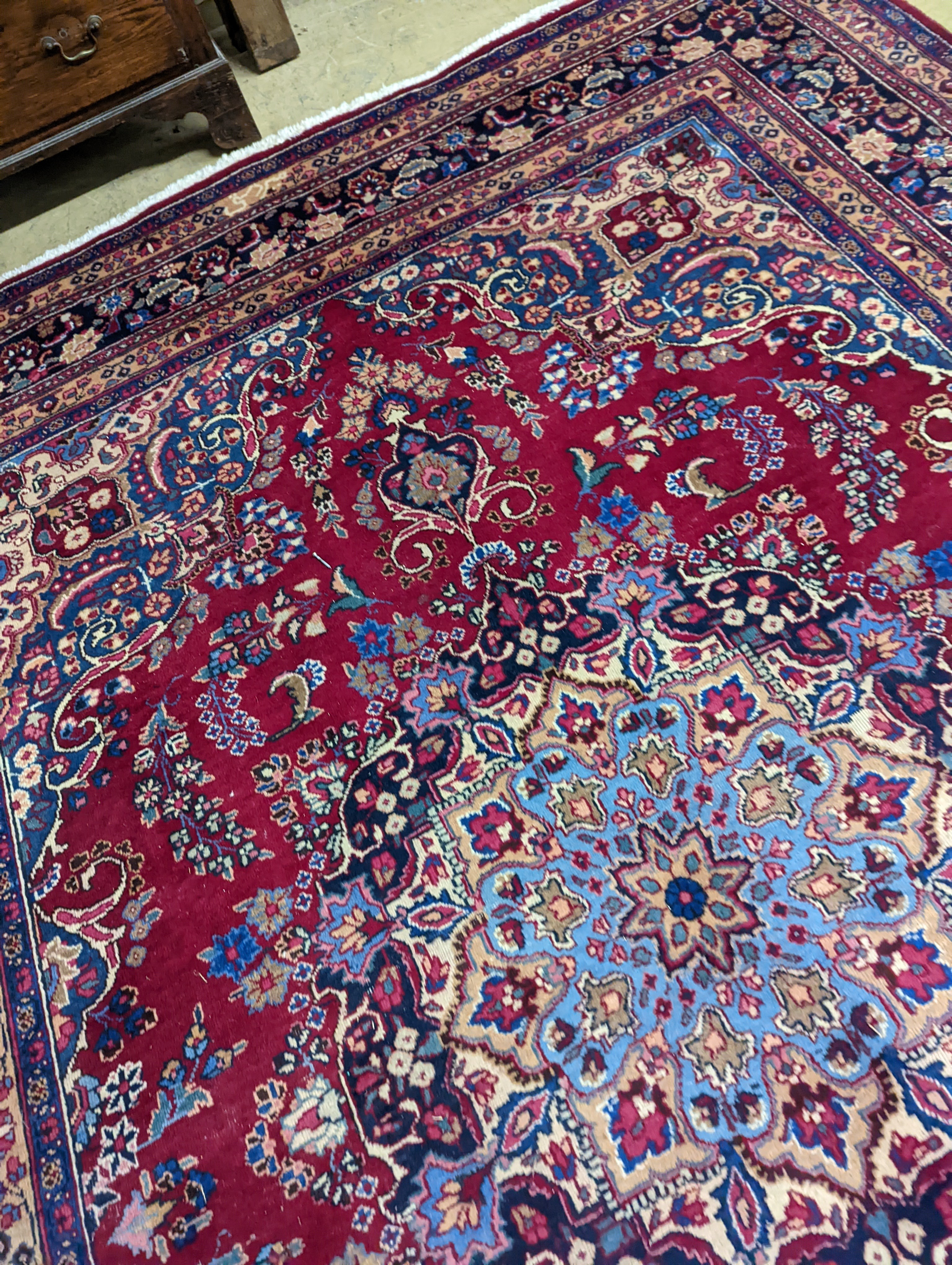 A Tabriz burgundy ground carpet, 350 x 250cm